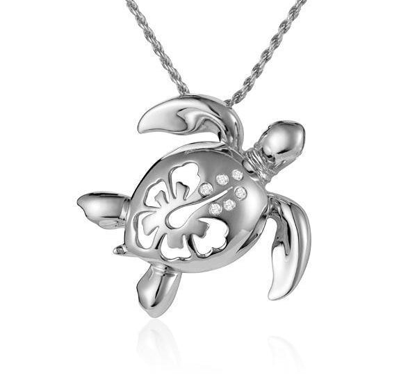In this photo there is a white gold sea turtle pendant with a hibiscus flower cut-out and six diamonds.