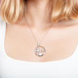 The picture shows a short hair model wearing a 925 sterling silver, white gold plated, two starfish circle pendant with topaz.