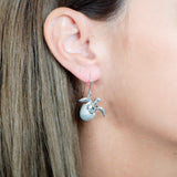 The picture shows a model wearing a 925 sterling silver turtle hatchling hook earring.