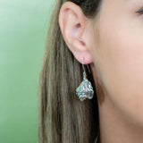 The picture shows a model wearing a 925 sterling silver conch shell earring.