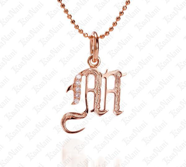 The picture shows a 14K rose gold Koa Nani M initial pendant.