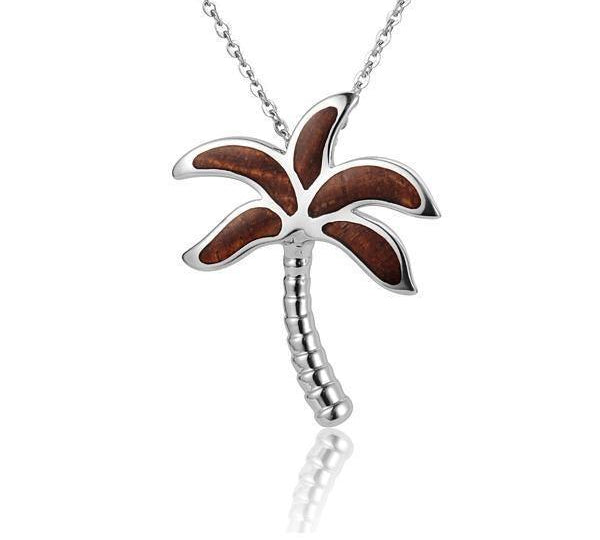 In this photo there is a small sterling silver and koa wood palm tree pendant.