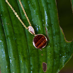 14K gold pendant with a circular Koa wood ornament and diamonds on the bail. 