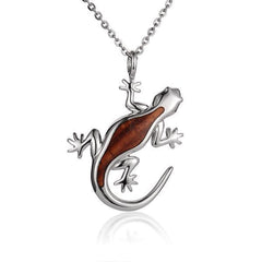 In this photo there is a sterling silver and koa wood gecko pendant.