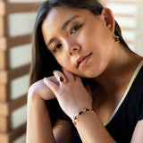 14k gold Koa wood tear drop ring worn by a model. 