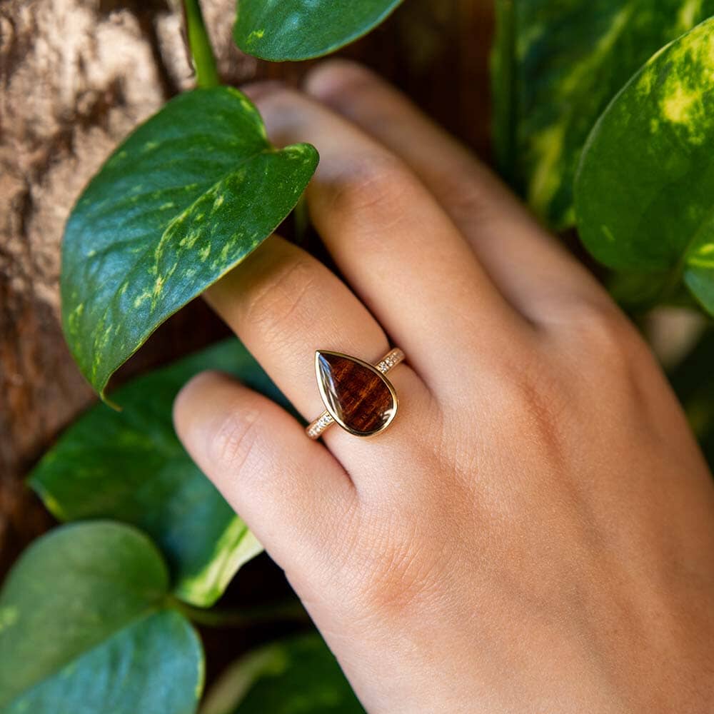 14k gold Koa wood tear drop ring with diamonds embedded in the band.
