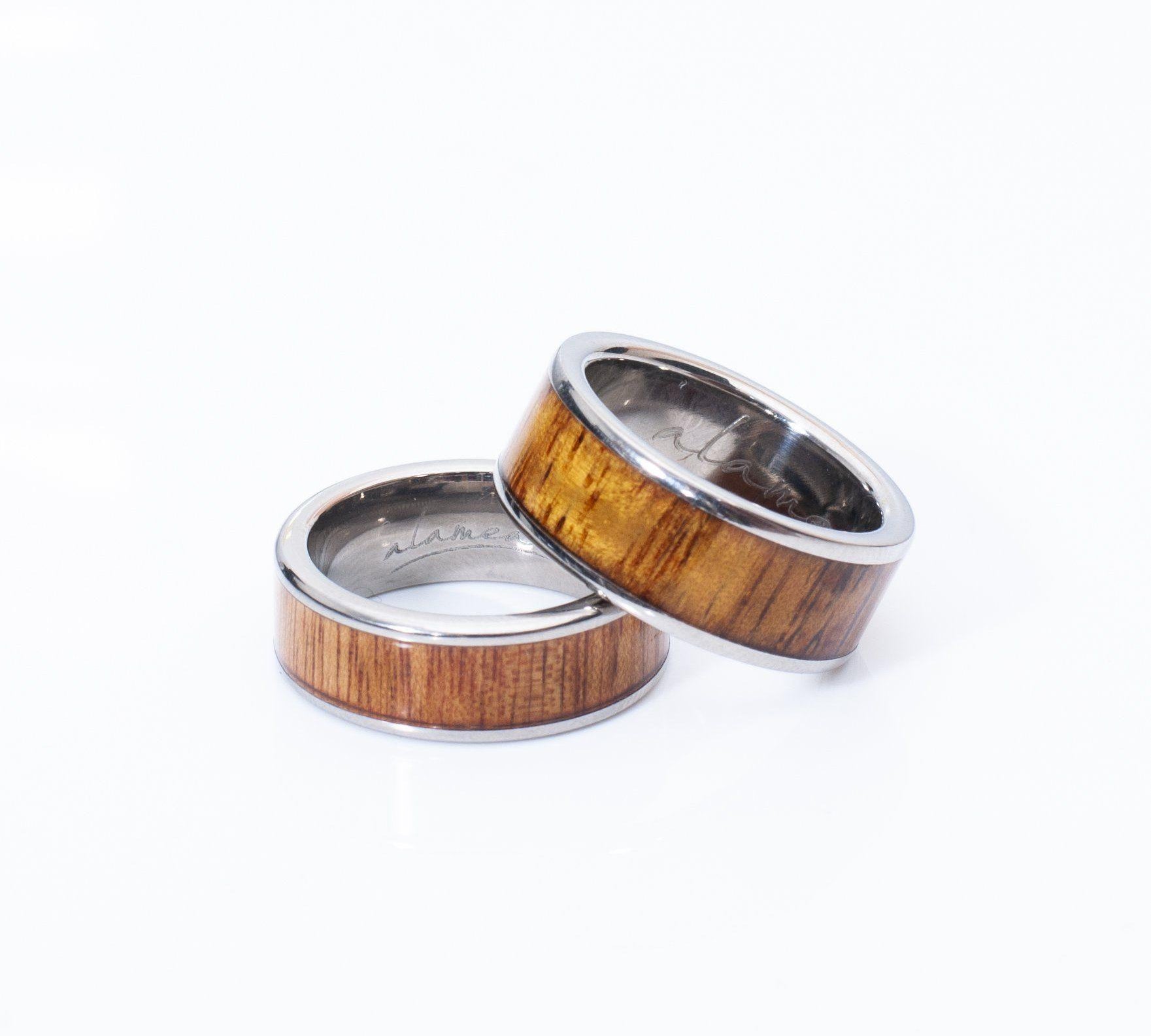In this photo there are two rings made of koa wood and titanium.