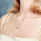 The picture shows a model wearing a 925 sterling silver starfish pendant with topaz.