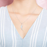 The picture shows a model wearing a 925 sterling silver mermaid pendant and a blue shirt with blue lines.