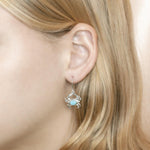 The picture shows a model wearing a 925 sterling silver larimar blue crab earring.