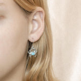The picture shows a model wearing a 925 sterling silver larimar blue crab earring.
