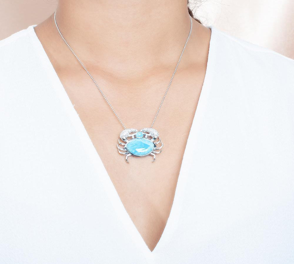 The picture shows a model wearing a 925 sterling silver larimar blue crab treasure pendant.
