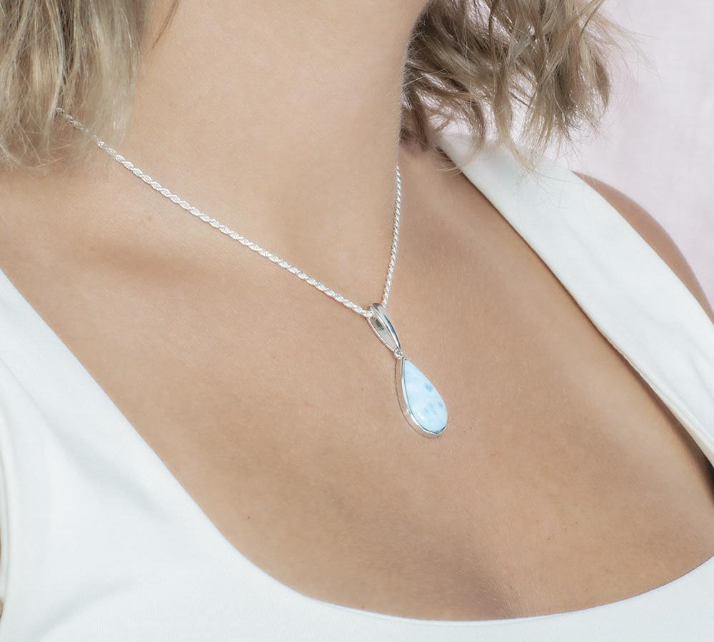 The picture shows a model wearing a 925 sterling silver larimar teardrop pendant.