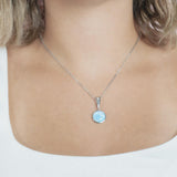 The picture shows a model wearing a 925 sterling silver larimar circle pendant.