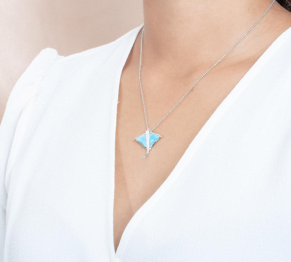 The picture shows a model wearing a 925 sterling silver larimar eagle ray pendant with cubic zirconia.