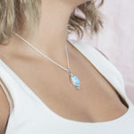 The picture shows a model wearing a 925 sterling silver larimar eye of the storm pendant.