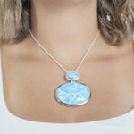The picture shows a model wearing a 925 sterling silver larimar pendant.