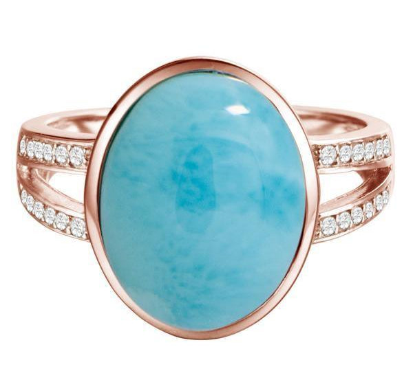 The picture shows a 14K rose gold larimar cocktail ring with a split band lined with diamonds and topaz gemstones