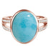 The picture shows a 14K rose gold larimar cocktail ring with a split band lined with diamonds and topaz gemstones