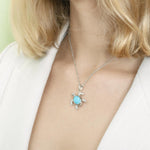 The picture shows a model wearing a 925 sterling silver larimar sea turtle pendant.