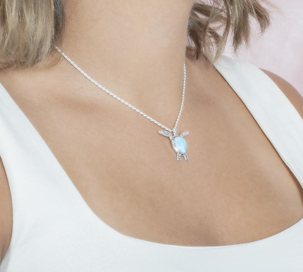 The picture shows a model wearing a 925 sterling silver larimar honu pendant.