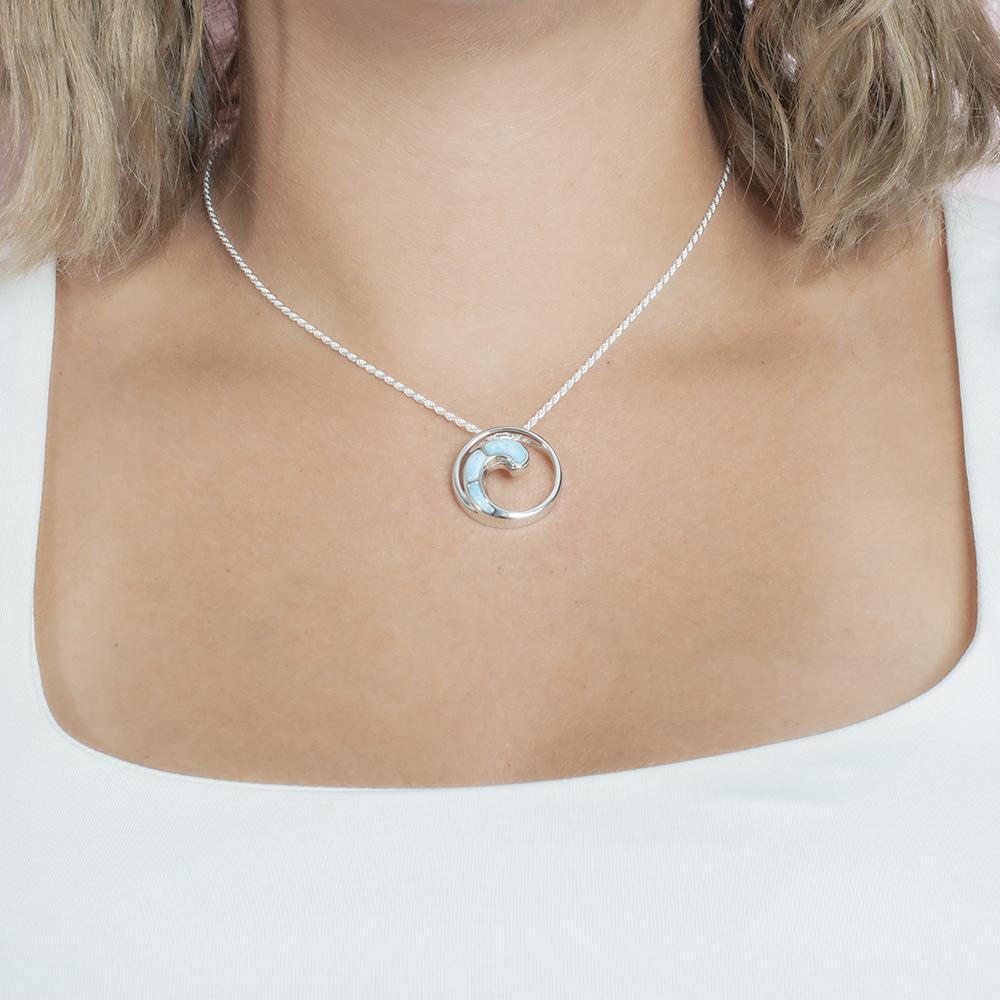 The picture shows a model wearing a 925 sterling silver larimar high tide pendant.