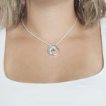 The picture shows a model wearing a 925 sterling silver larimar high tide pendant.