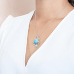 The picture shows a model wearing a 925 sterling silver larimar sea turtle pendant.