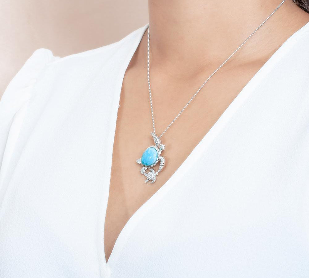 The picture shows a model wearing a 925 sterling silver larimar sea turtle pendant.