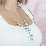 The picture shows a model wearing a 925 sterling silver larimar sea turtle charm necklace.