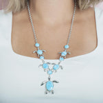 The picture shows a model wearing a 925 sterling silver larimar sea turtle charm necklace.