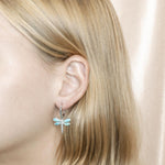 In this photo is a model wearing 925 sterling silver dragonfly lever-back earrings with blue larimar and aquamarine gemstones.