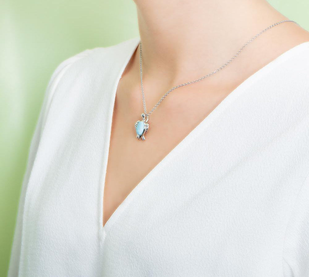 The picture shows a model wearing a 925 sterling silver larimar sea turtle pendant.