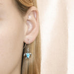 The picture shows a model wearing a 925 sterling silver larimar sea turtle hook earring.