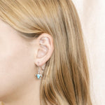 The picture shows a model wearing a 925 sterling silver larimar sea turtle hook earring.