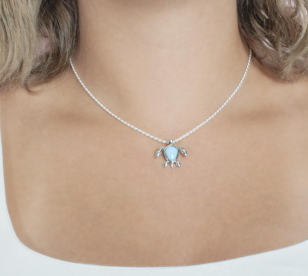 The picture shows a model wearing a 925 sterling silver larimar sea turtle pendant.
