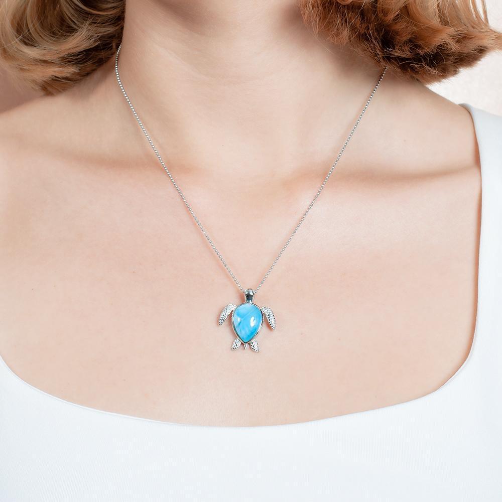 The picture shows a model wearing a 925 sterling silver larimar sea turtle pendant.