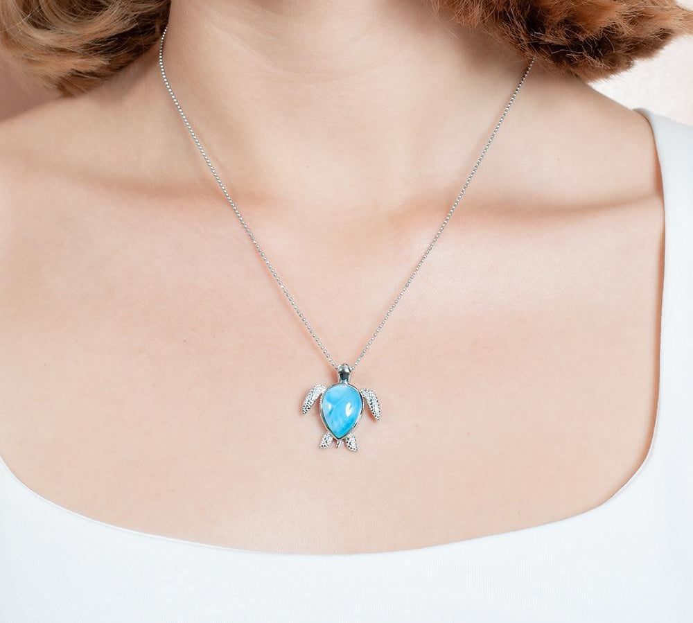 The picture shows a model wearing a 925 sterling silver larimar sea turtle pendant.