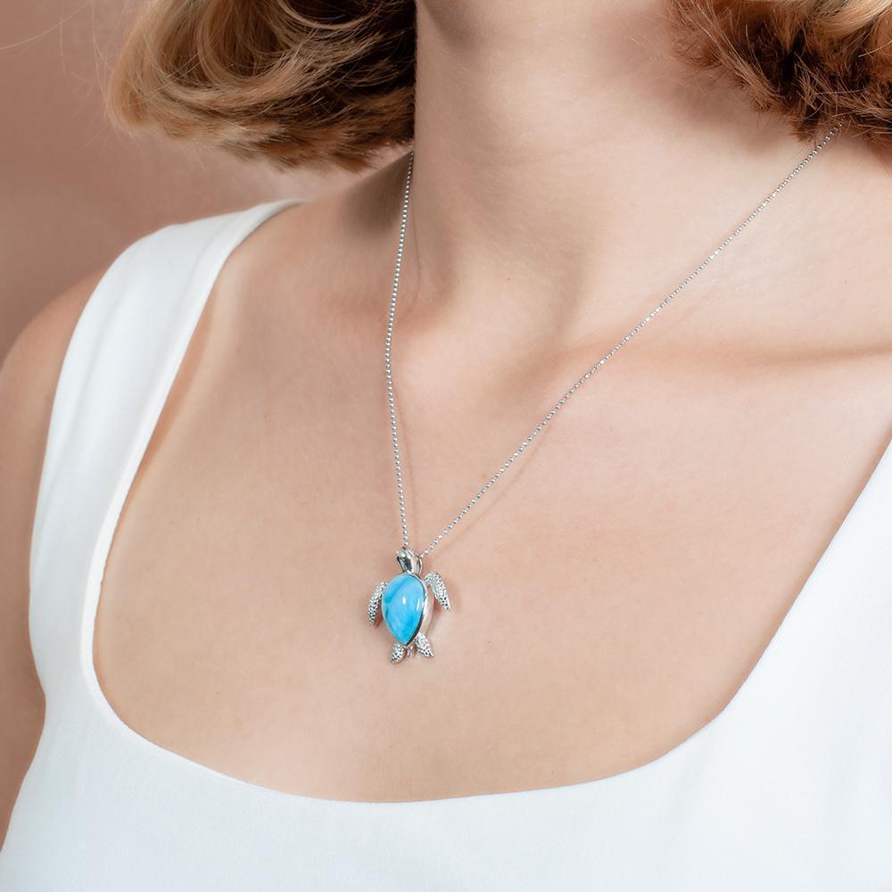 The picture shows a model wearing a 925 sterling silver larimar sea turtle pendant.