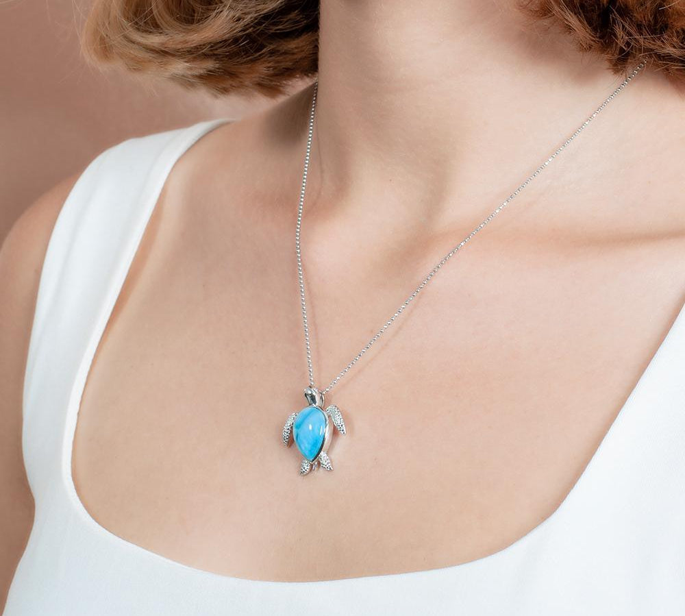 The picture shows a model wearing a 925 sterling silver larimar sea turtle pendant.