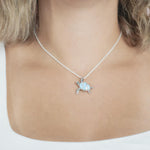 The picture shows a model wearing a 925 sterling silver larimar sea turtle pendant with topaz.