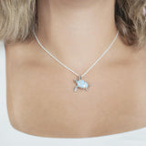 The picture shows a model wearing a 925 sterling silver larimar sea turtle pendant with topaz.
