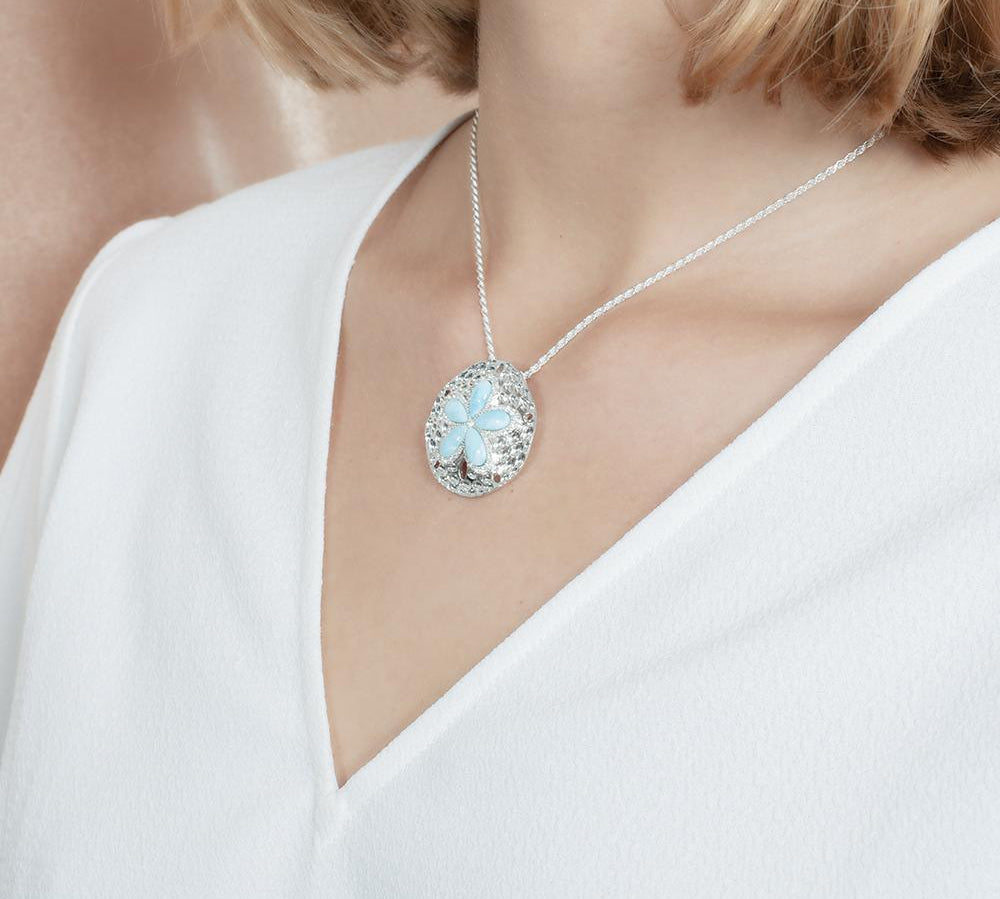 The picture shows a model wearing a 925 sterling silver larimar living sand dollar pendant.