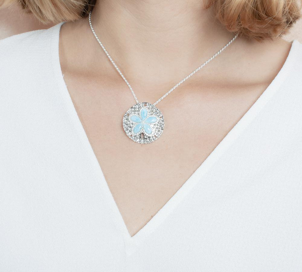 The picture shows a model wearing a 925 sterling silver larimar living sand dollar pendant.