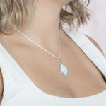 The picture shows a model wearing a 925 sterling silver larimar loa mandorla pendant.