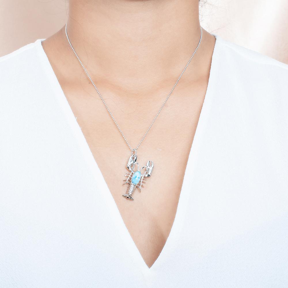The picture shows a model wearing a 925 sterling silver larimar lobster pendant.