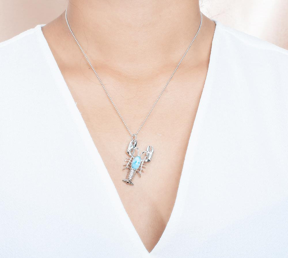 The picture shows a model wearing a 925 sterling silver larimar lobster pendant.