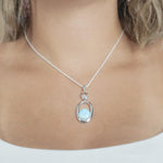 The picture shows a model wearing a 925 sterling silver larimar lunar eclipse pendant.