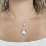 The picture shows a model wearing a 925 sterling silver larimar lunar eclipse pendant.
