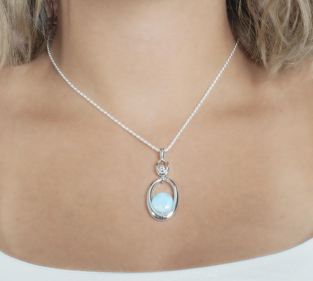 The picture shows a model wearing a 925 sterling silver larimar lunar eclipse pendant.